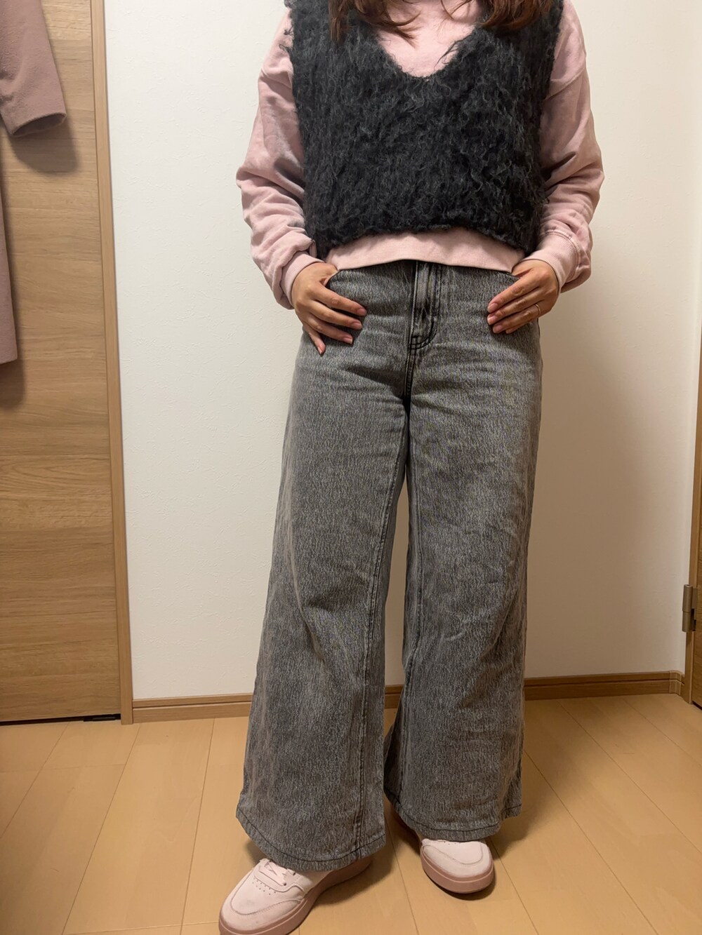 グレー系のデニムパンツ、ピンク系のスニーカー、ピンク系のTシャツ/カットソーを着用したレディースの冬コーディネートの2枚目の写真