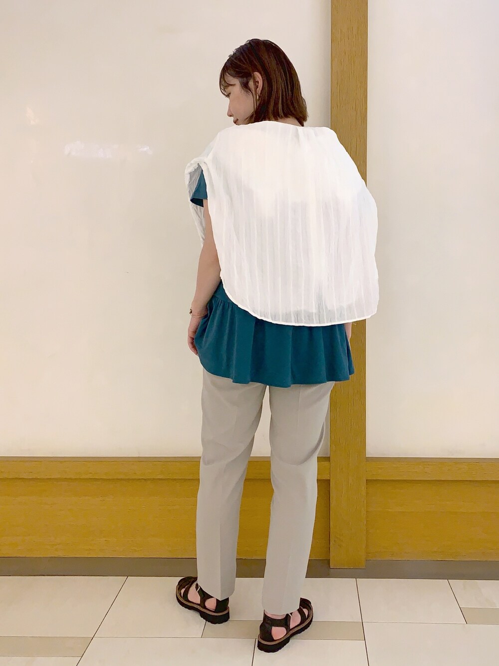 グリーン系のTシャツ/カットソー、ホワイト系のシャツ/ブラウス、ベージュ系のその他パンツを着用したレディースの春コーディネートの2枚目の写真