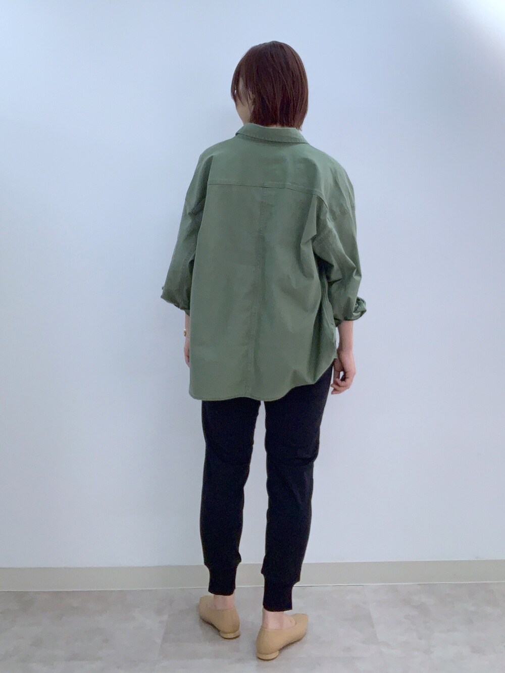 グリーン系のミリタリージャケット、ベージュ系のニット/セーター、ブルー系のその他パンツを着用したレディースの夏コーディネートの2枚目の写真