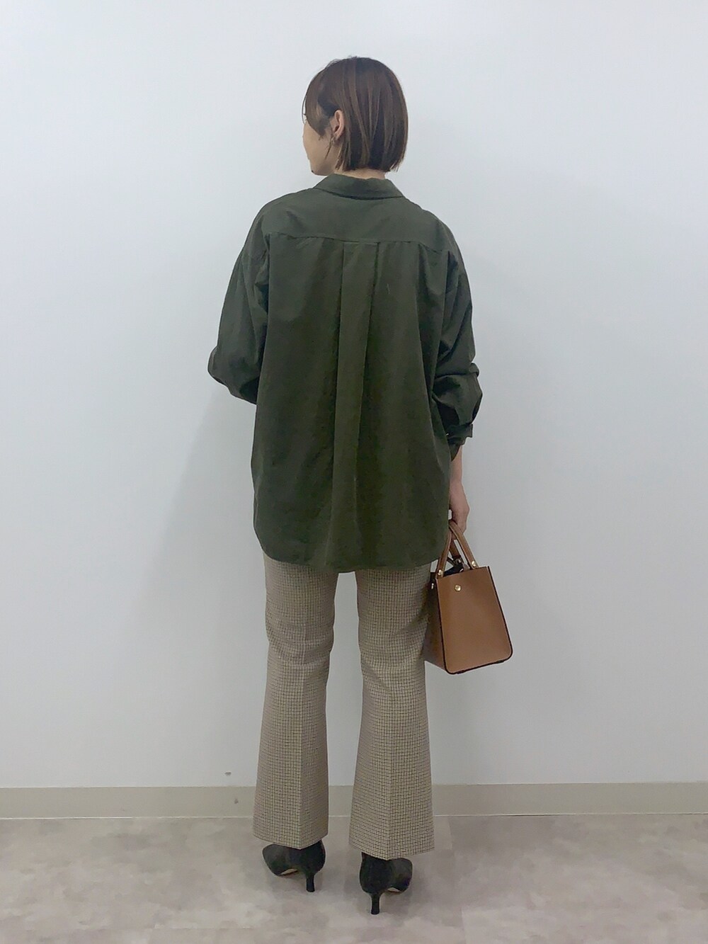グリーン系のシャツ/ブラウス、ベージュ系のパンツ、ブラック系のシューズを着用したレディースの秋コーディネートの2枚目の写真