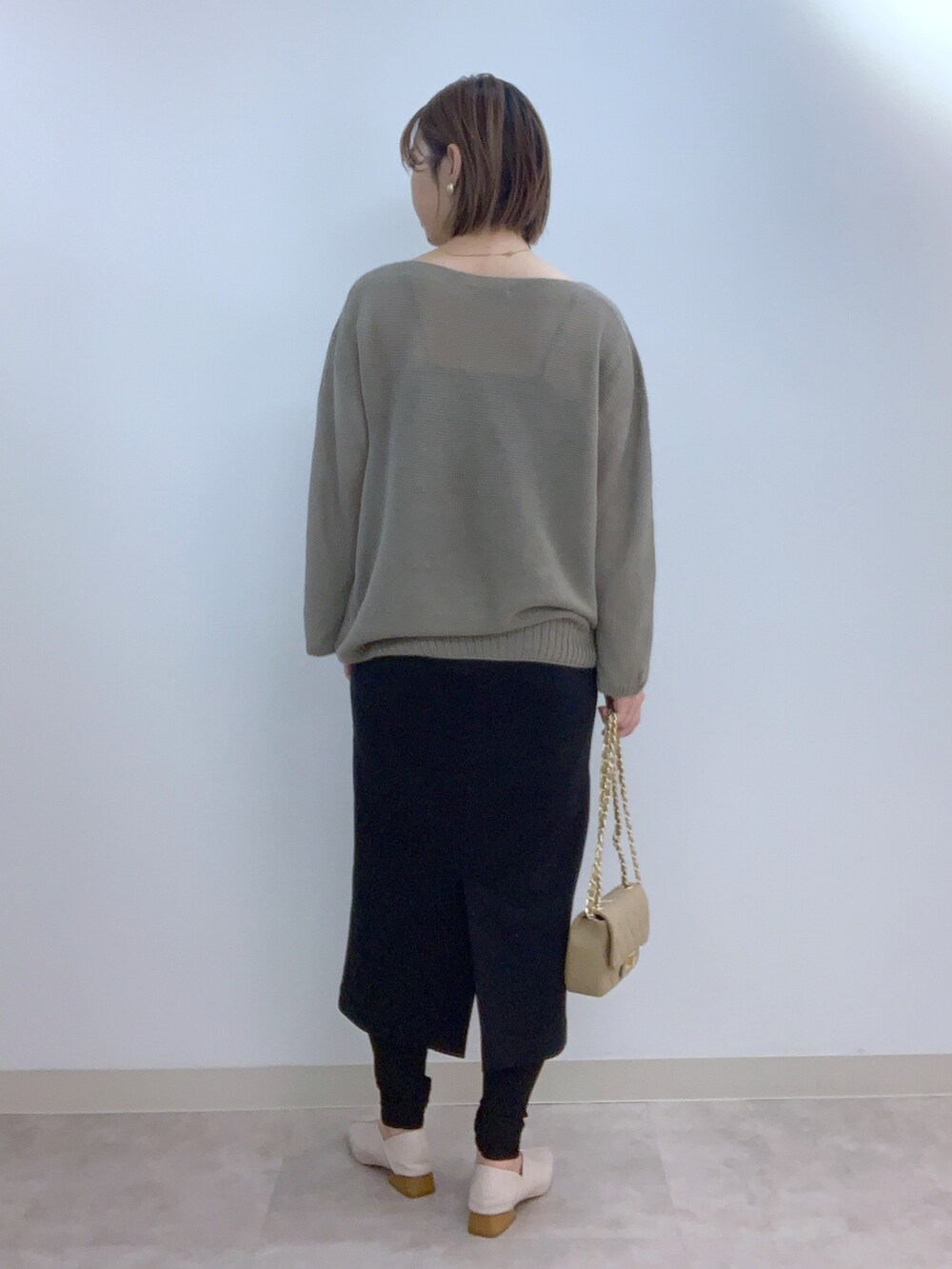 ベージュ系のニット/セーター、ブラック系のスカート、ブラック系のバッグを着用したレディースの夏コーディネートの2枚目の写真