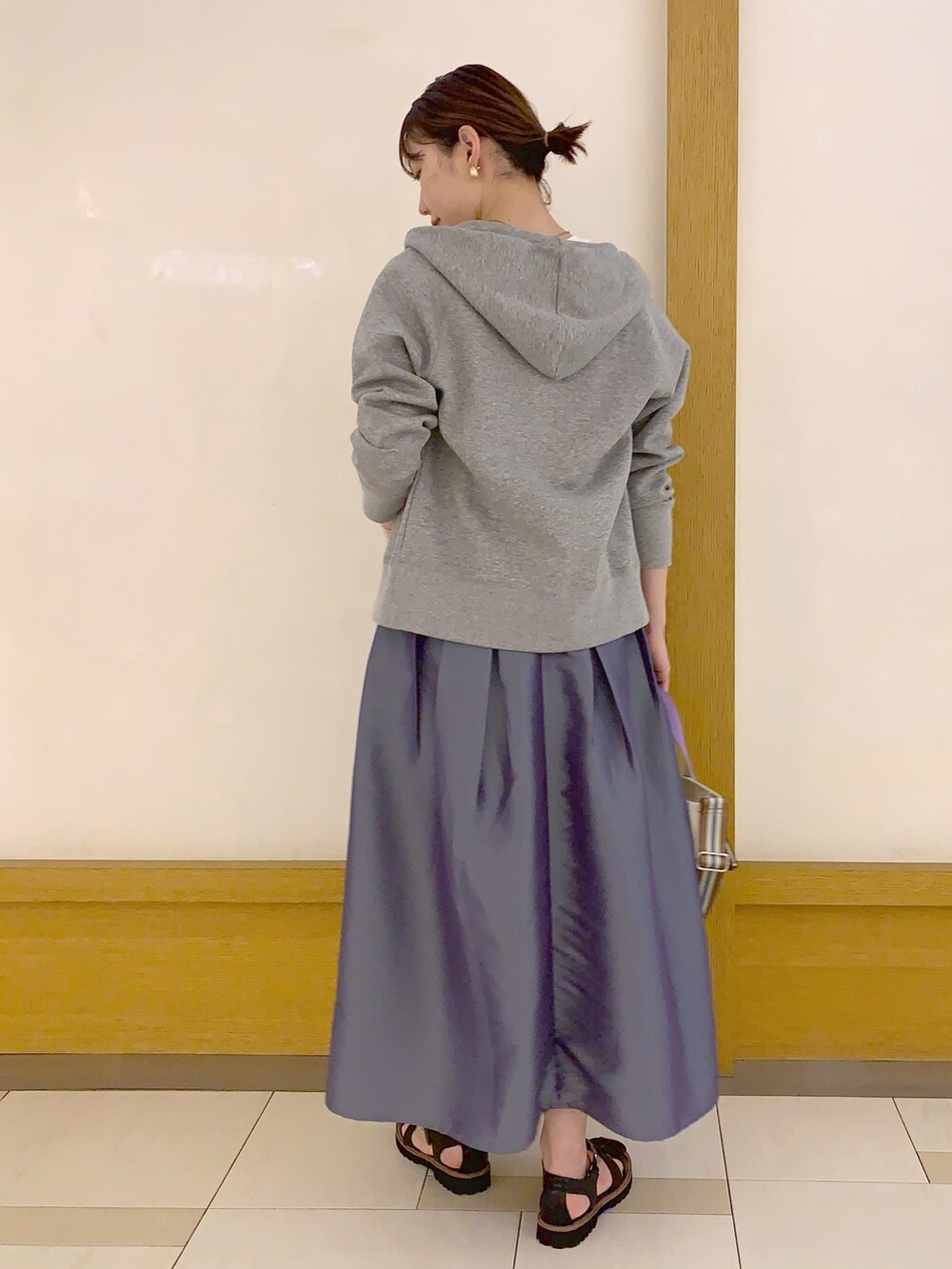 ホワイト系のTシャツ/カットソー、グレー系のパーカー、ブルー系のスカートを着用したレディースの春コーディネートの2枚目の写真