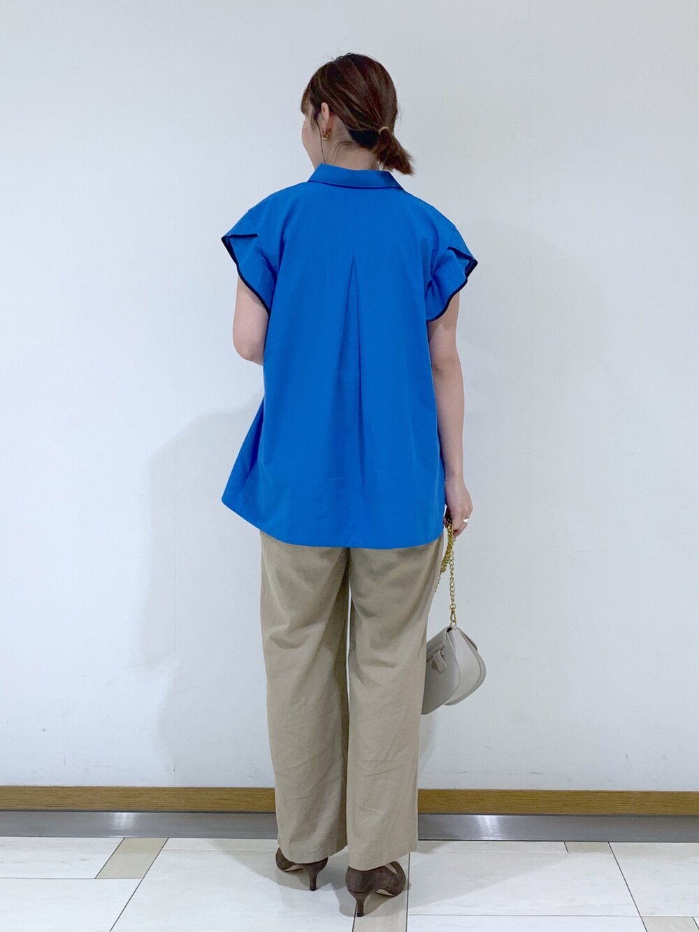 ブルー系のトップス、ベージュ系のその他パンツ、イエロー系のボディバッグ/ウエストポーチを着用したレディースの夏コーディネートの2枚目の写真