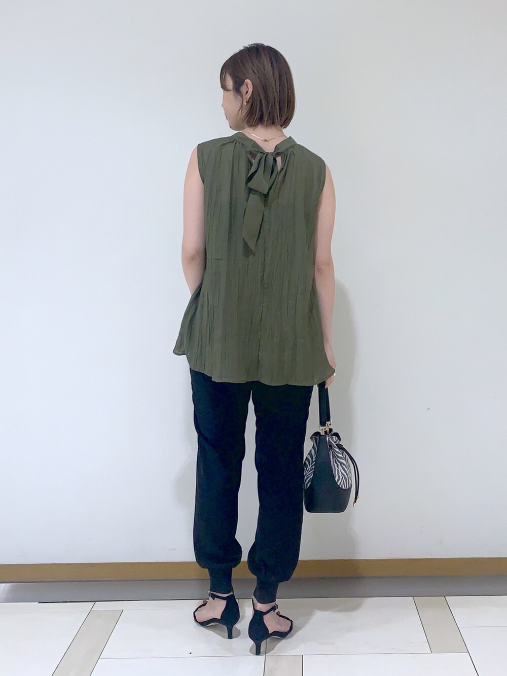 グリーン系のシャツ/ブラウス、ブラック系のその他パンツ、ブラック系のシューズを着用したレディースの夏コーディネートの2枚目の写真