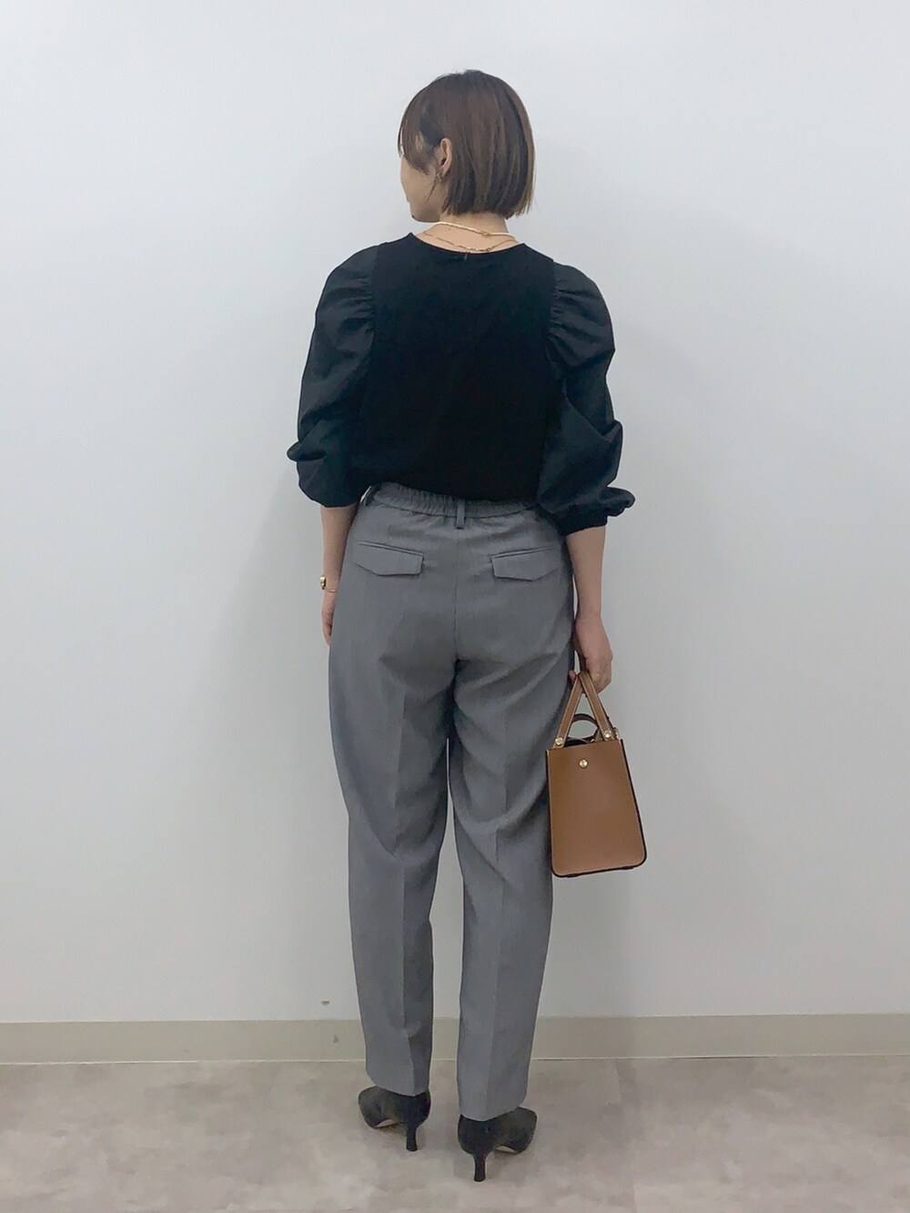 ブラック系のTシャツ/カットソー、グレー系のその他パンツ、ブラック系のシューズを着用したレディースの秋コーディネートの2枚目の写真