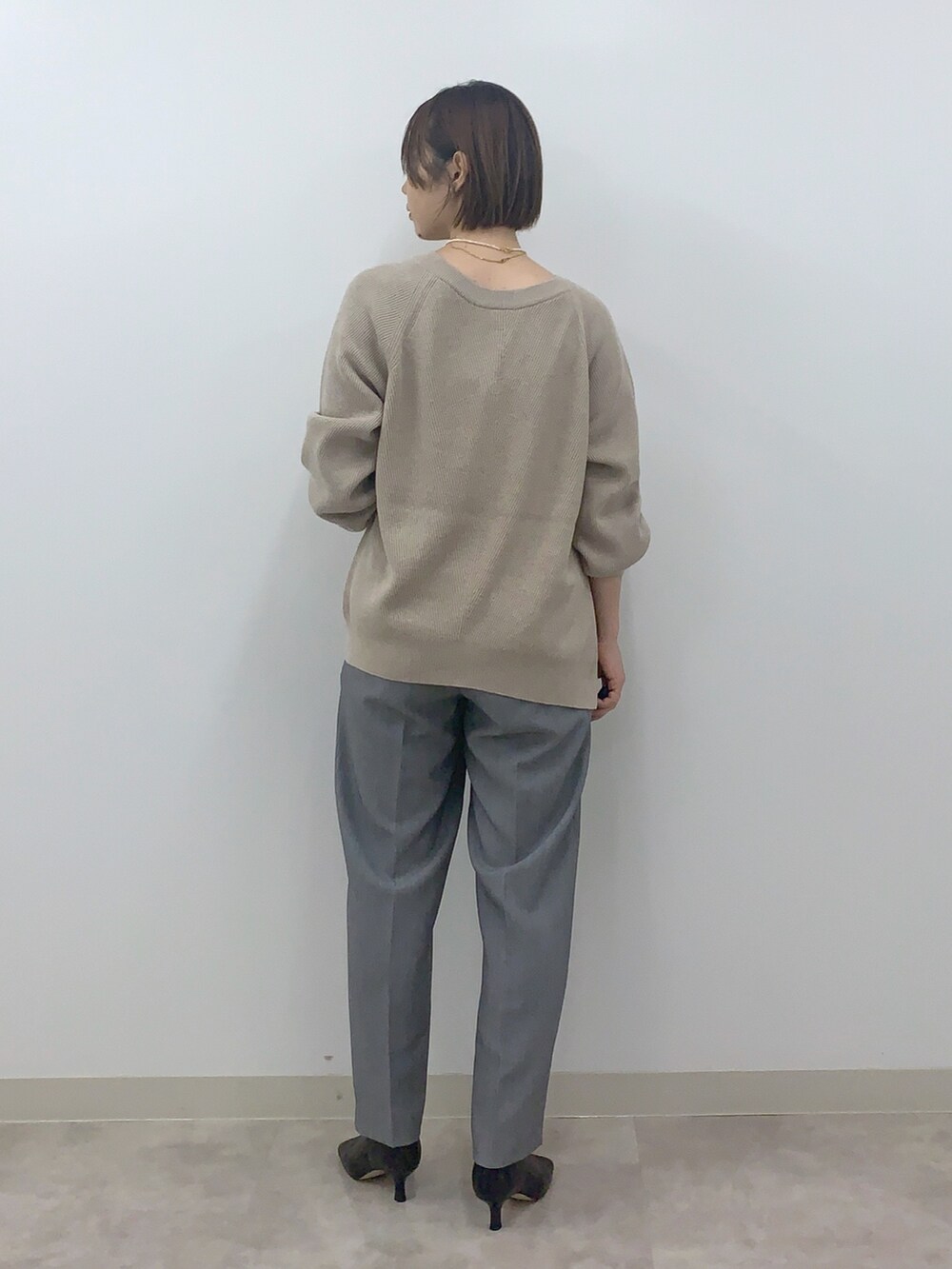 ベージュ系のカーディガン/ボレロ、グレー系のその他パンツ、ブラック系のシューズを着用したレディースの秋コーディネートの2枚目の写真