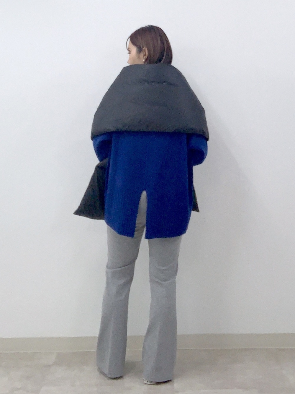 ブルー系のニット/セーター、グレー系のその他パンツ、ブラック系のストール/ショールを着用したレディースの秋コーディネートの2枚目の写真