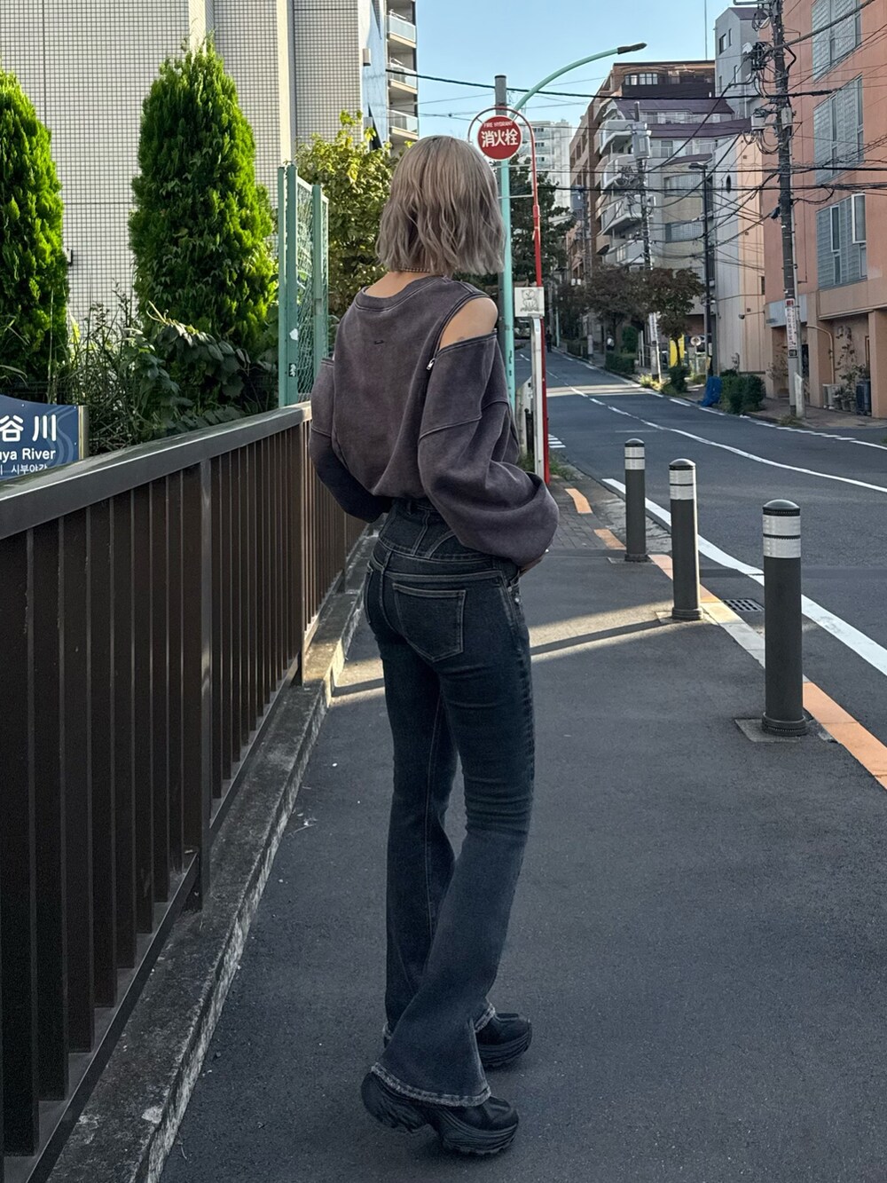 ブルー系のデニムパンツ、ブラック系のスニーカーを着用したレディースの秋コーディネートの2枚目の写真