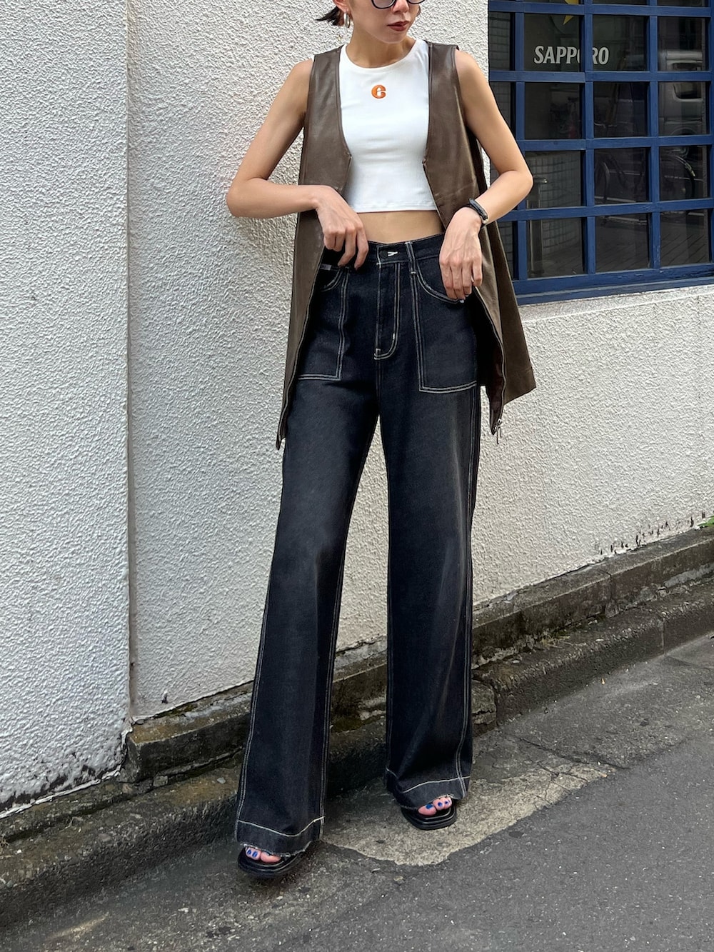 ブラック系のデニムパンツ、ブラック系のワンピース、ホワイト系のタンクトップを着用したレディースの夏コーディネートの2枚目の写真