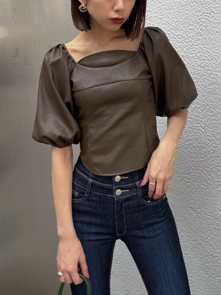 ブラウン系のTシャツ/カットソー、グリーン系のハンドバッグ、ブルー系のデニムパンツを着用したレディースの秋コーディネートの3枚目の写真
