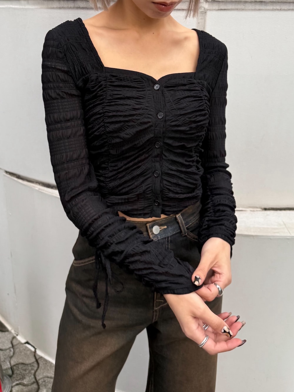 ブルー系のデニムパンツ、ブラック系のTシャツ/カットソー、ブラック系のローファーを着用したレディースの春コーディネートの6枚目の写真