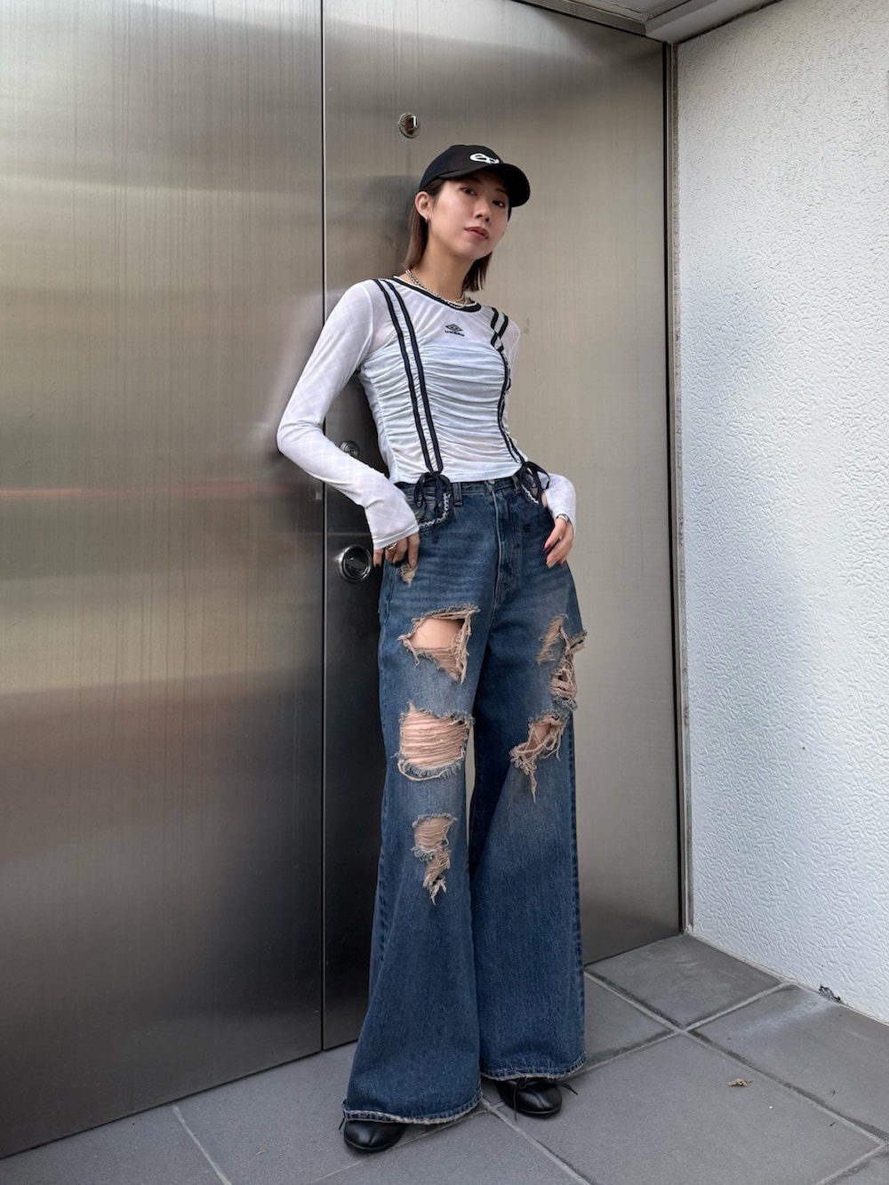 ブルー系のデニムパンツ、ホワイト系のTシャツ/カットソー、ブラック系のスニーカーを着用したレディースの冬コーディネートの4枚目の写真