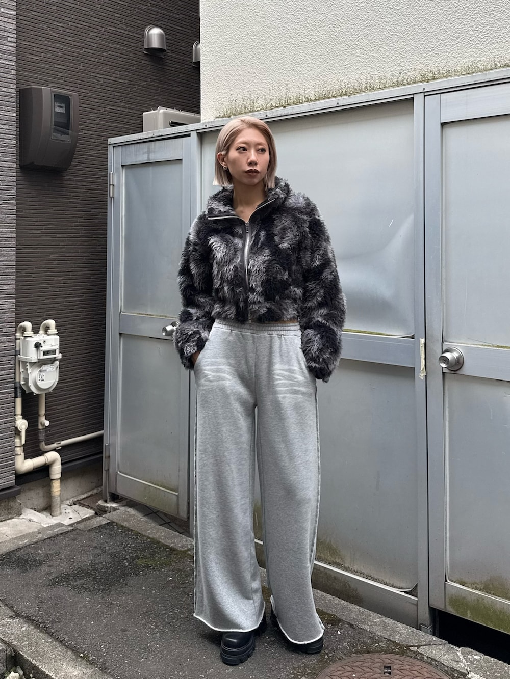 ブルー系のブルゾン、グレー系のスウェットパンツ、ブラック系のブーツを着用したレディースの秋コーディネートの4枚目の写真