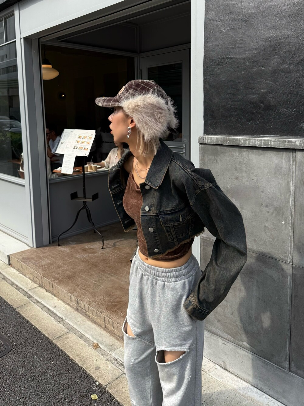 ブルー系のデニムジャケット、グレー系のスウェットパンツ、ベージュ系のキャップを着用したレディースの秋コーディネートの4枚目の写真