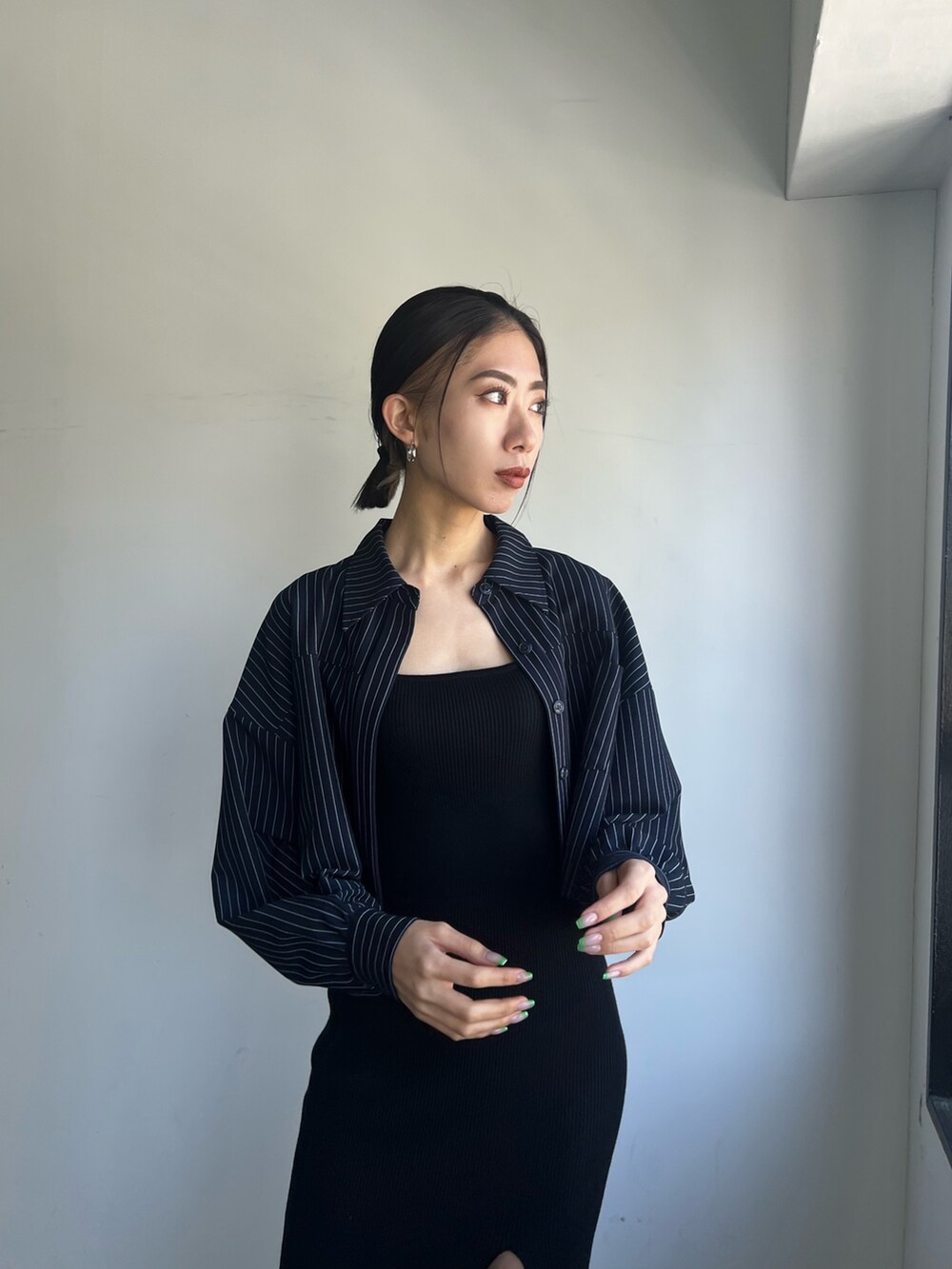 ブラック系のワンピース、ブラック系のブーツを着用したレディースの春コーディネートの2枚目の写真