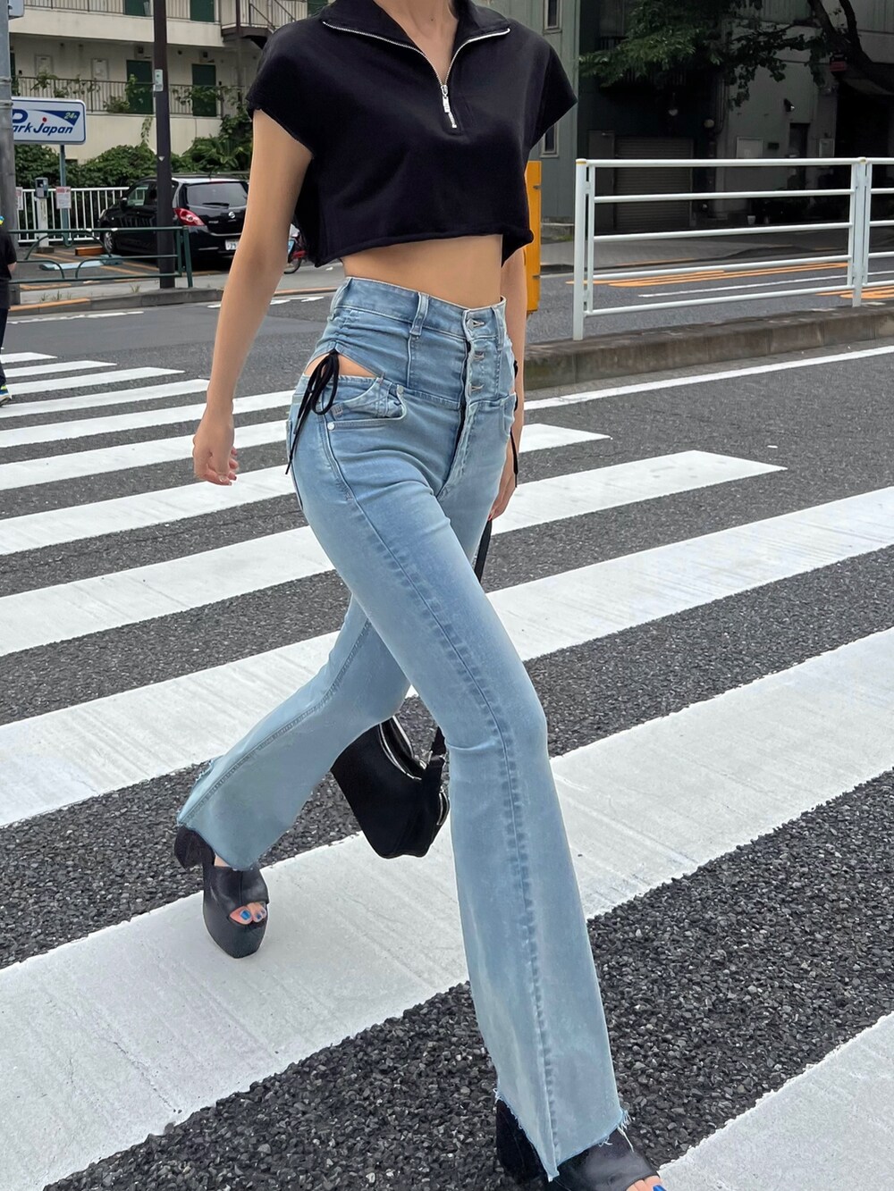 ブルー系のデニムパンツ、ブラック系のTシャツ/カットソー、ブラック系のサンダルを着用したレディースの夏コーディネートの5枚目の写真