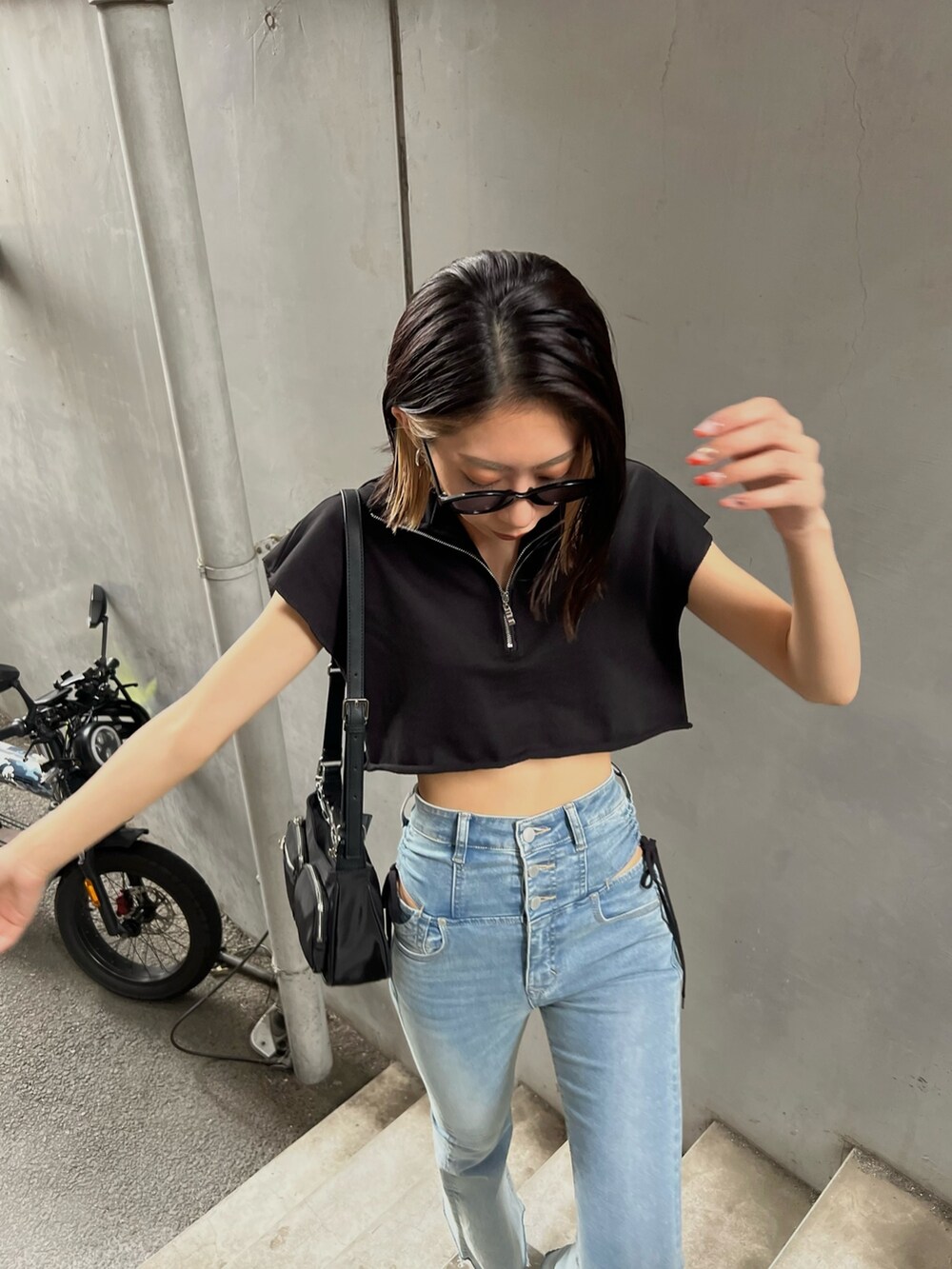 ブルー系のデニムパンツ、ブラック系のTシャツ/カットソー、ブラック系のサンダルを着用したレディースの夏コーディネートの4枚目の写真