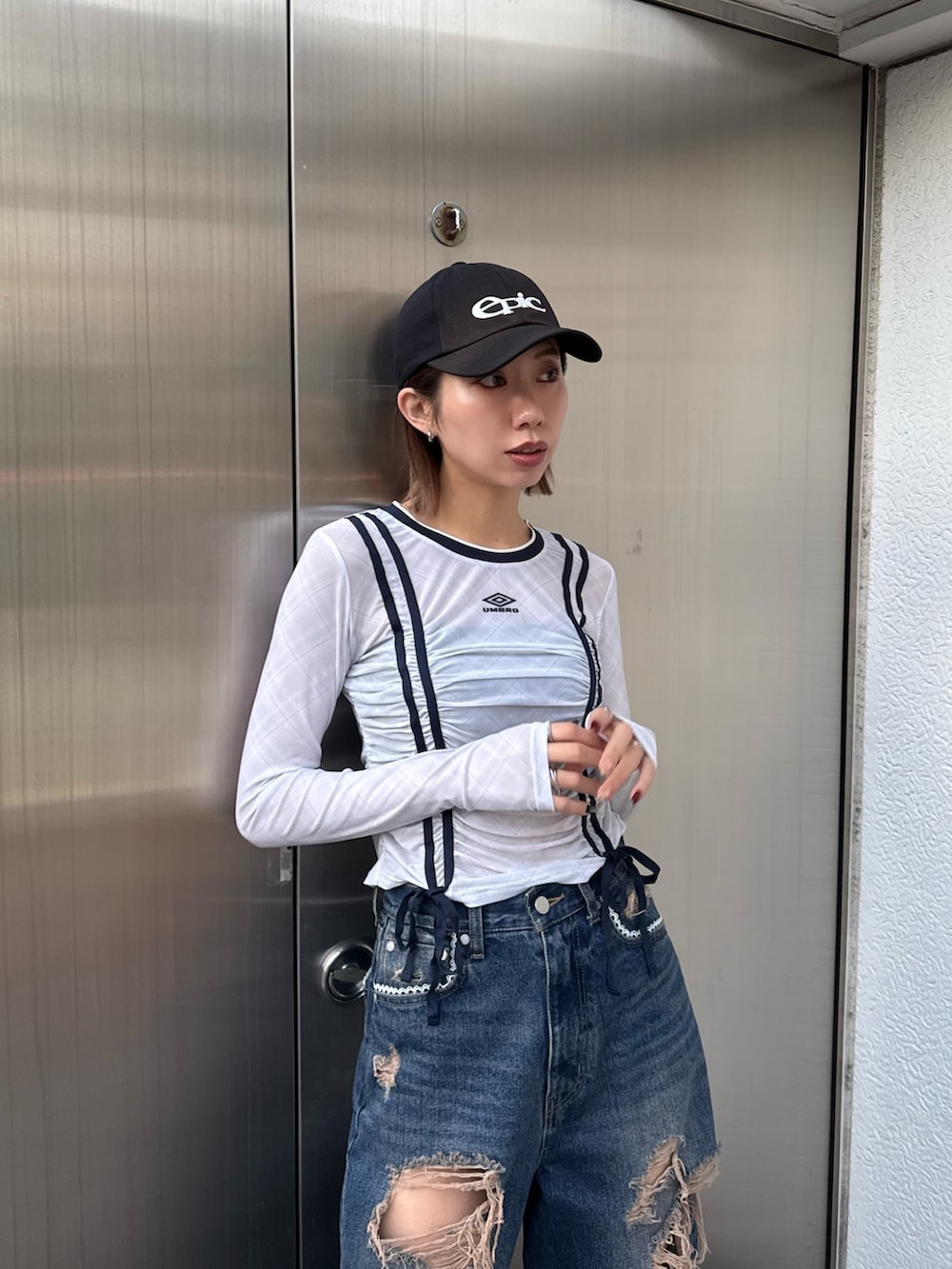 ブルー系のデニムパンツ、ホワイト系のTシャツ/カットソー、ブラック系のスニーカーを着用したレディースの冬コーディネートの2枚目の写真