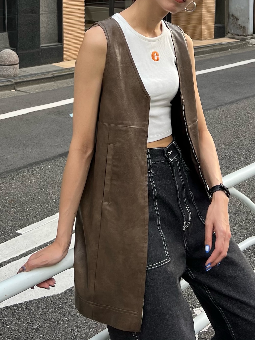 ブラック系のデニムパンツ、ブラック系のワンピース、ホワイト系のタンクトップを着用したレディースの夏コーディネートの4枚目の写真