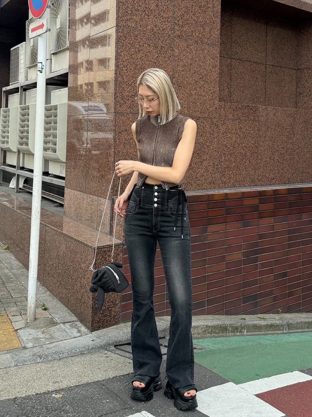 ブラック系のデニムパンツ、ブラック系のハンドバッグ、ブラック系のサンダルを着用したレディースの夏コーディネートの2枚目の写真