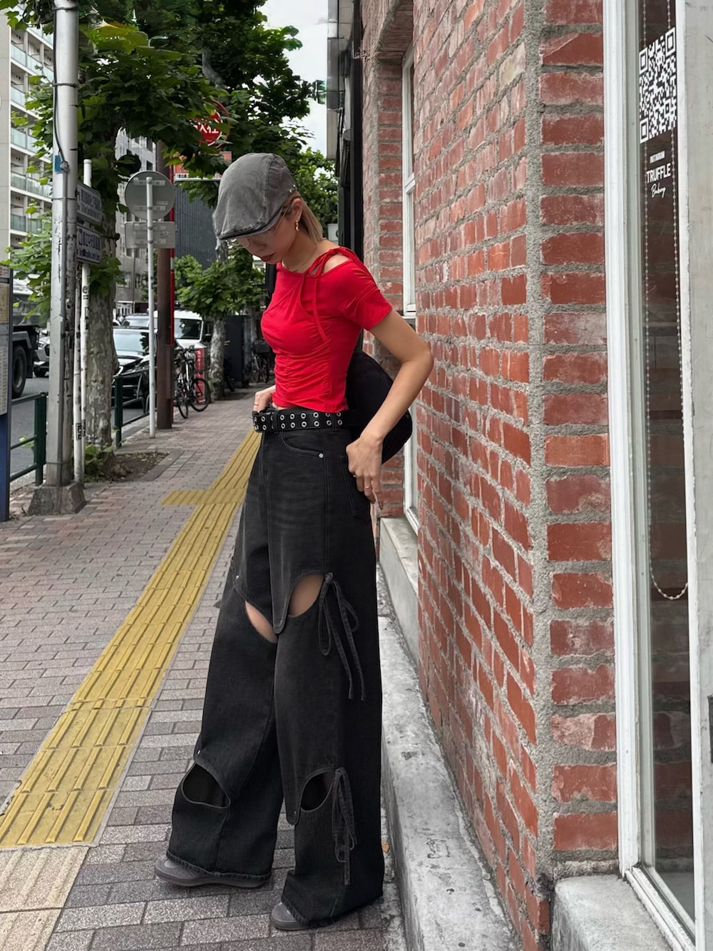 レッド系のTシャツ/カットソー、ブラック系のデニムパンツ、グレー系のハンチング/ベレー帽を着用したレディースの夏コーディネートの2枚目の写真