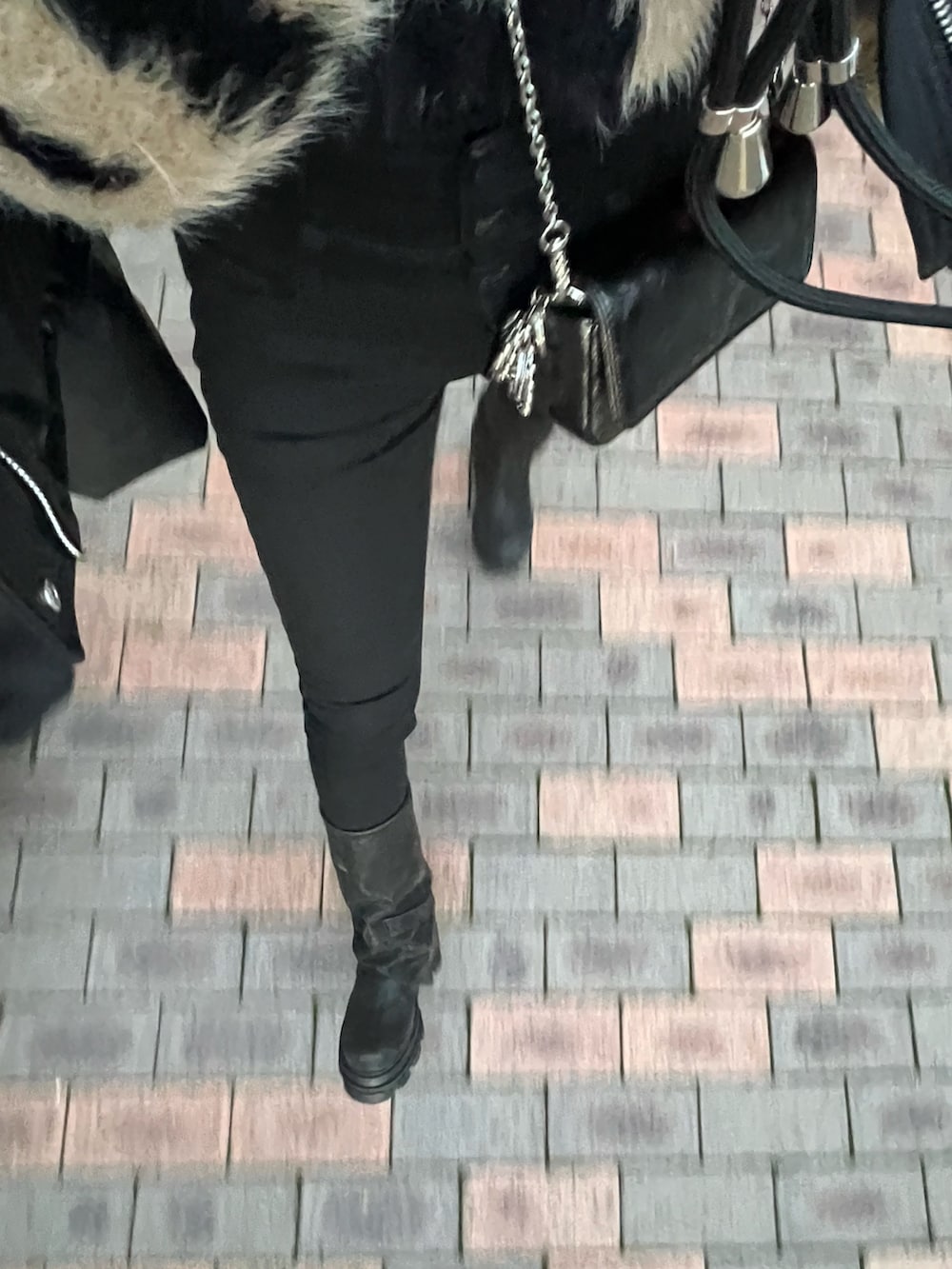 ブラック系のデニムパンツ、ブラック系のブーツ、ブラック系のダウンジャケット/コートを着用したレディースの冬コーディネートの4枚目の写真