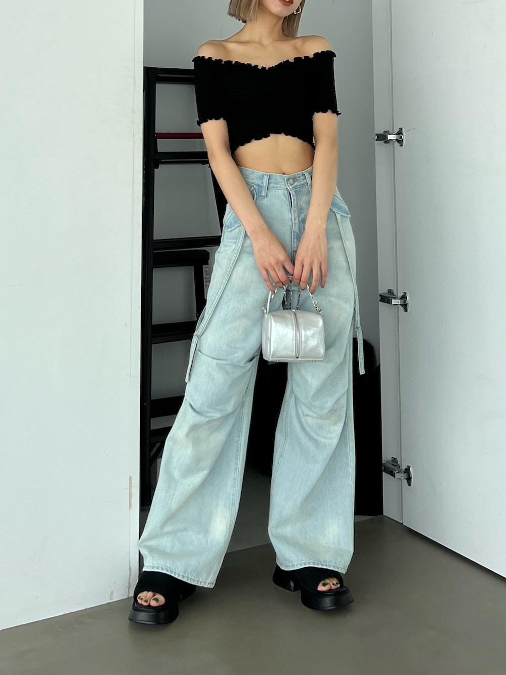 ブルー系のデニムパンツ、ブラック系のTシャツ/カットソー、シルバー系のハンドバッグを着用したレディースの夏コーディネートの2枚目の写真