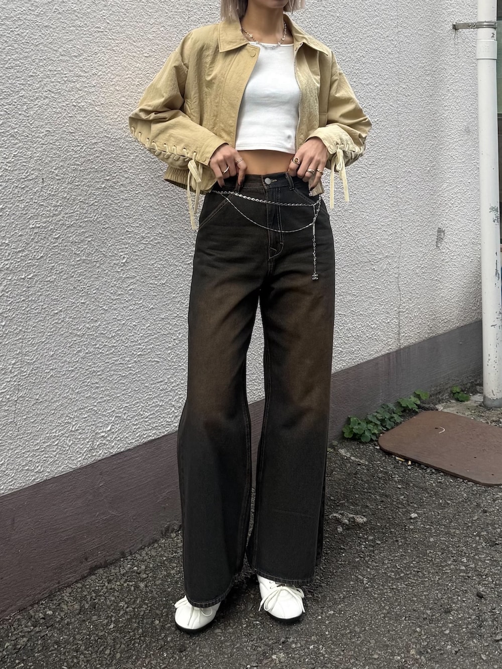 ブルー系のデニムパンツ、ホワイト系のスニーカー、イエロー系のブルゾンを着用したレディースの冬コーディネートの3枚目の写真