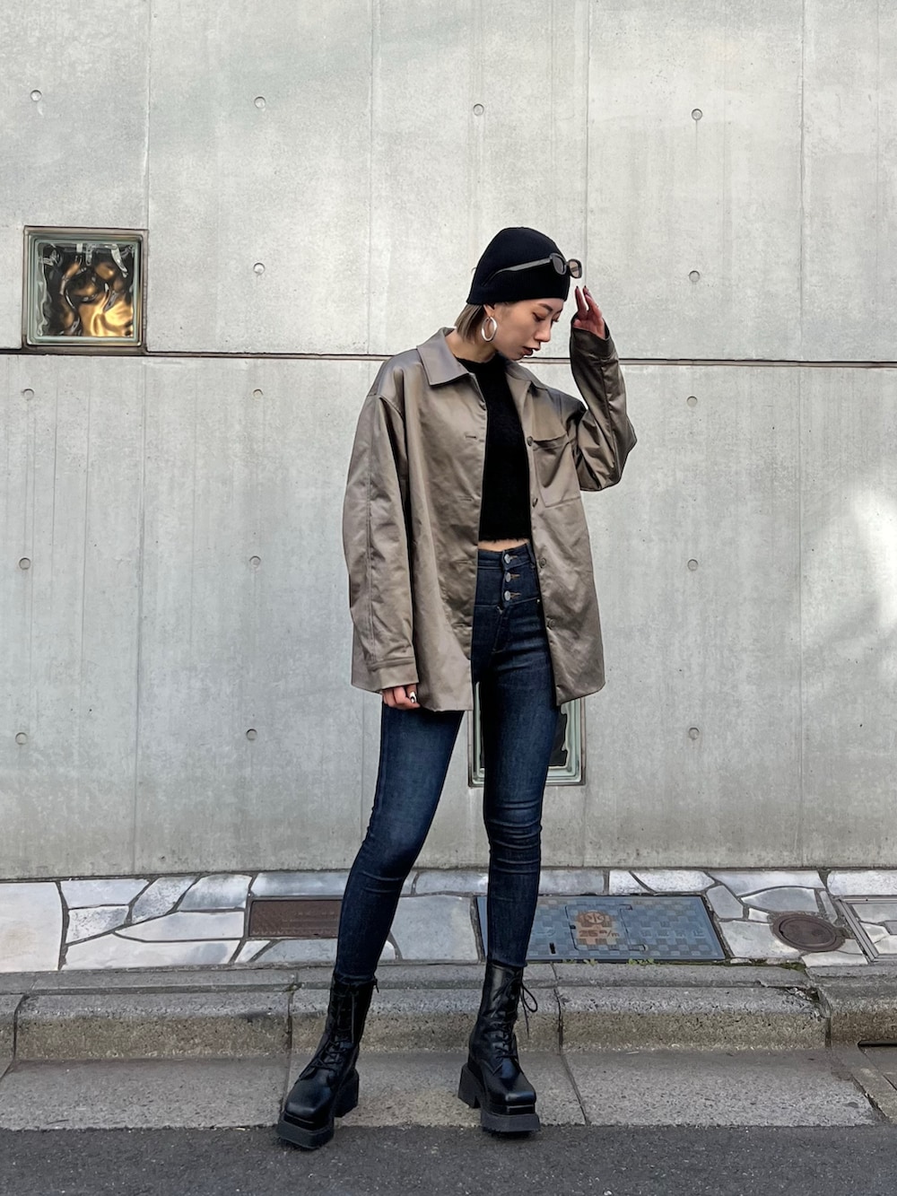 ブルー系のデニムパンツ、ブラック系のブーツ、ブラウン系のナイロンジャケットを着用したレディースの春コーディネートの2枚目の写真