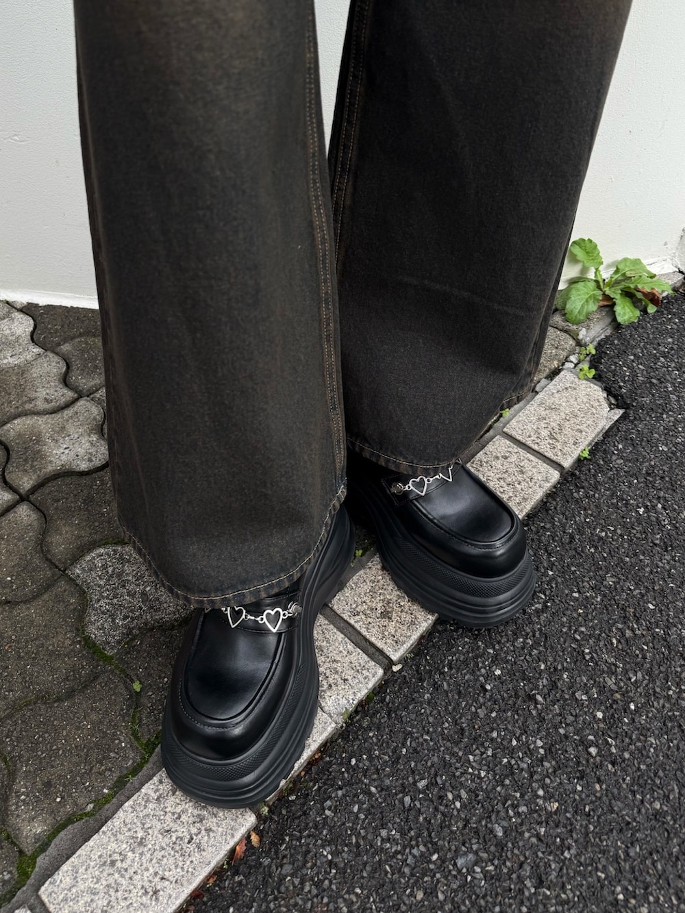 ブルー系のデニムパンツ、ブラック系のTシャツ/カットソー、ブラック系のローファーを着用したレディースの春コーディネートの3枚目の写真
