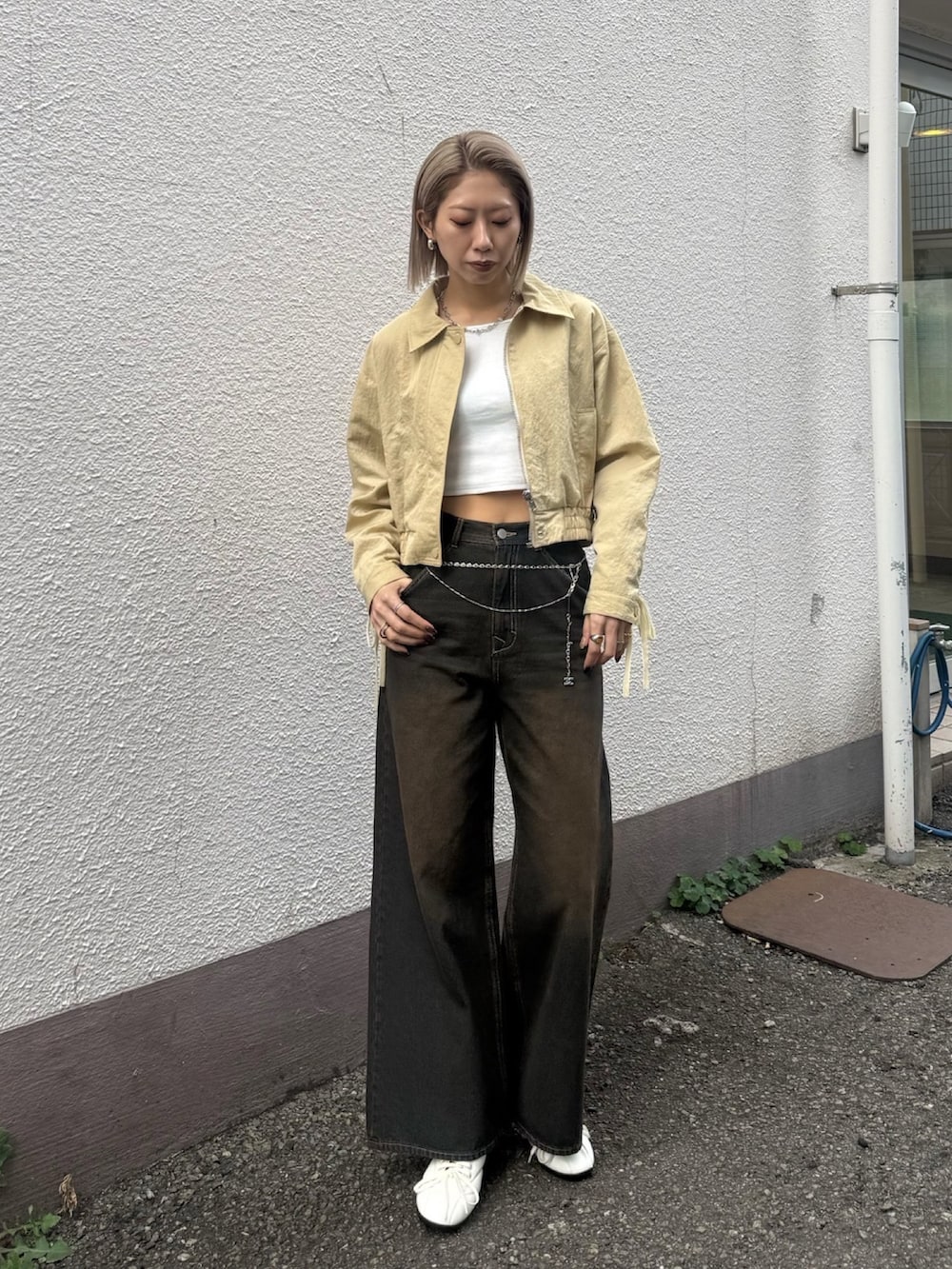 ブルー系のデニムパンツ、ホワイト系のスニーカー、イエロー系のブルゾンを着用したレディースの冬コーディネートの2枚目の写真