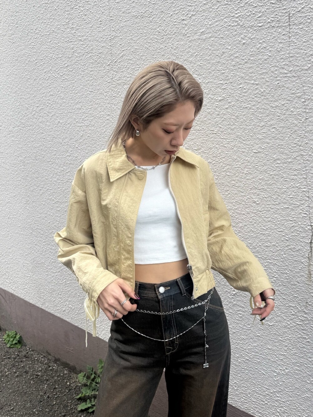 ブルー系のデニムパンツ、ホワイト系のスニーカー、イエロー系のブルゾンを着用したレディースの冬コーディネートの4枚目の写真