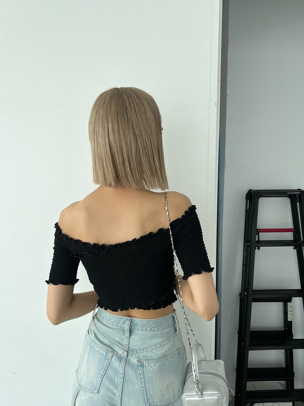 ブルー系のデニムパンツ、ブラック系のTシャツ/カットソー、シルバー系のハンドバッグを着用したレディースの夏コーディネートの5枚目の写真