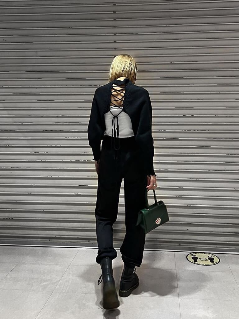 ブラック系のその他パンツ、ブラック系のニット/セーター、ホワイト系のキャミソールを着用したレディースの秋コーディネートの2枚目の写真