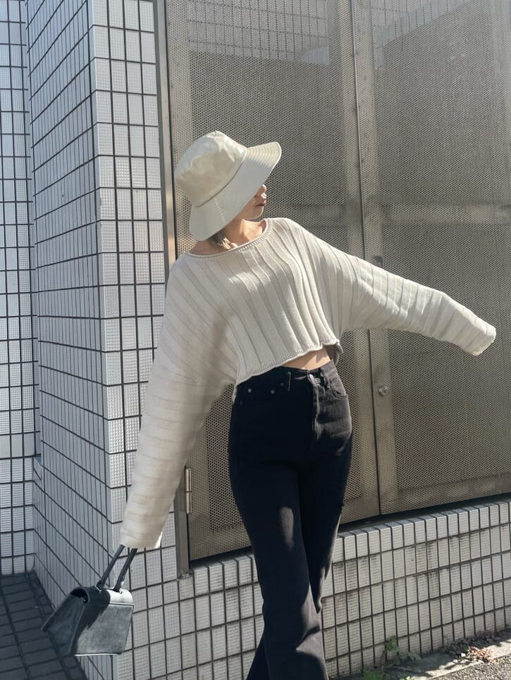 ホワイト系のニット/セーター、ブラック系のデニムパンツ、ホワイト系のハットを着用したレディースの冬コーディネートの3枚目の写真