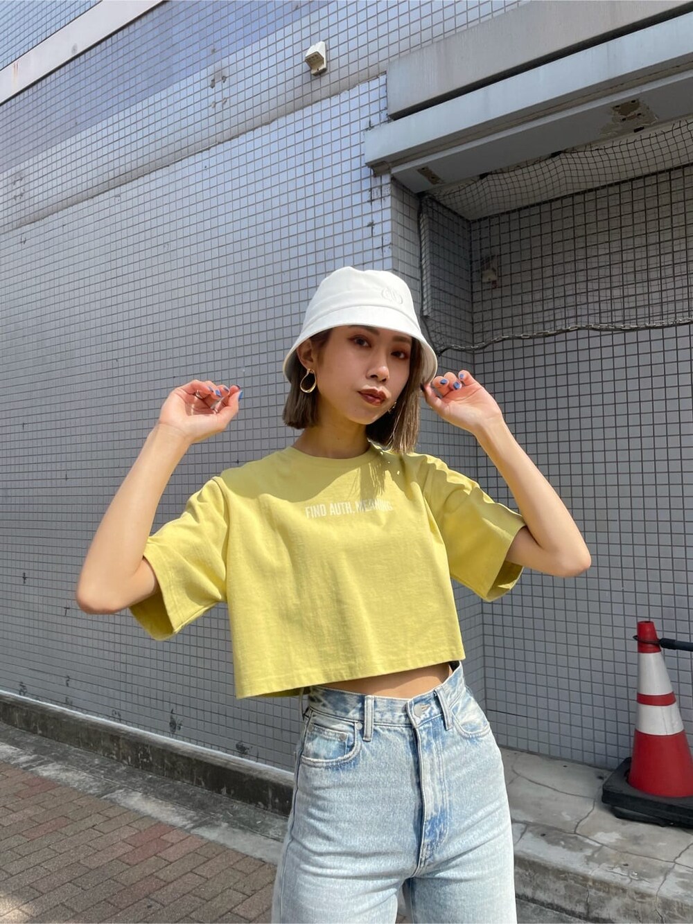 ブルー系のデニムパンツ、イエロー系のTシャツ/カットソー、ホワイト系のサンダルを着用したレディースの春コーディネートの4枚目の写真
