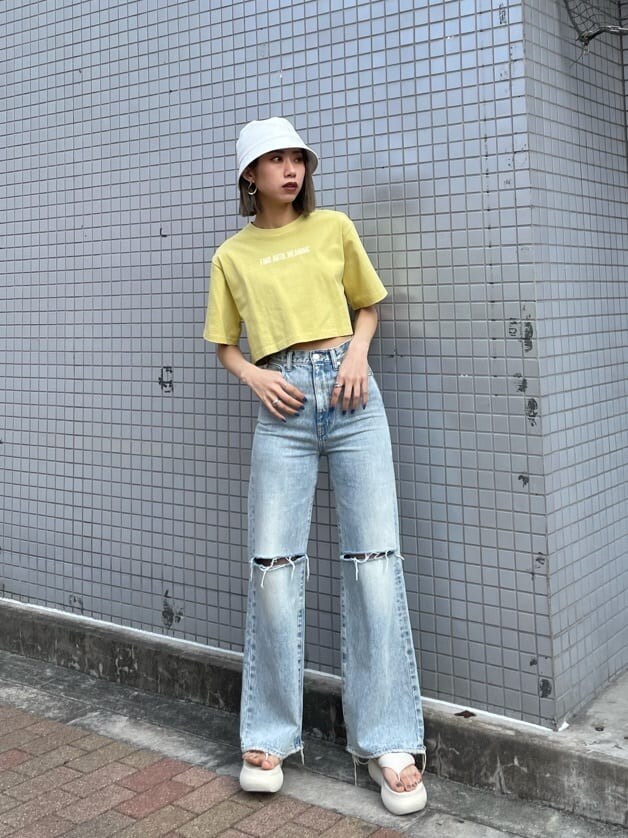 ブルー系のデニムパンツ、イエロー系のTシャツ/カットソー、ホワイト系のサンダルを着用したレディースの春コーディネートの3枚目の写真