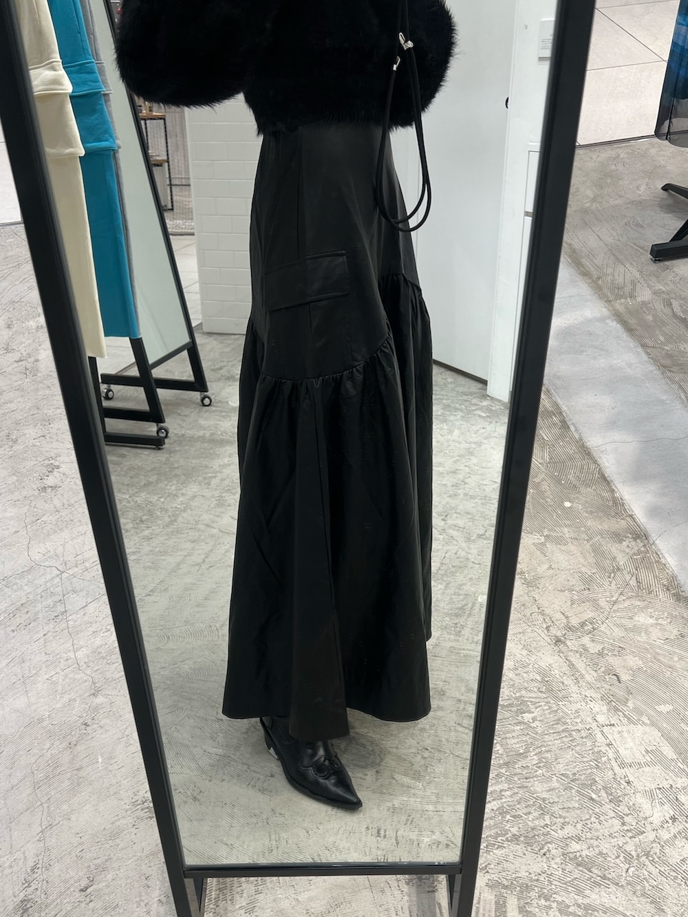 ブラック系のスカート、ブラック系のニット/セーター、ブラック系のブーツを着用したレディースの秋コーディネートの3枚目の写真