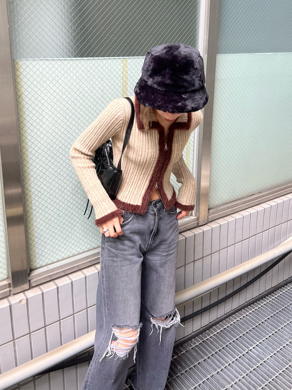 グレー系のデニムパンツ、ブラック系のローファー、ブラック系のショルダーバッグを着用したレディースの秋コーディネートの3枚目の写真