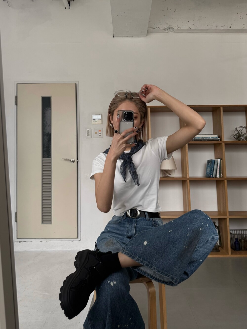 ブルー系のデニムパンツ、ブラック系のハンドバッグ、ブラック系のサンダルを着用したレディースの春コーディネートの4枚目の写真