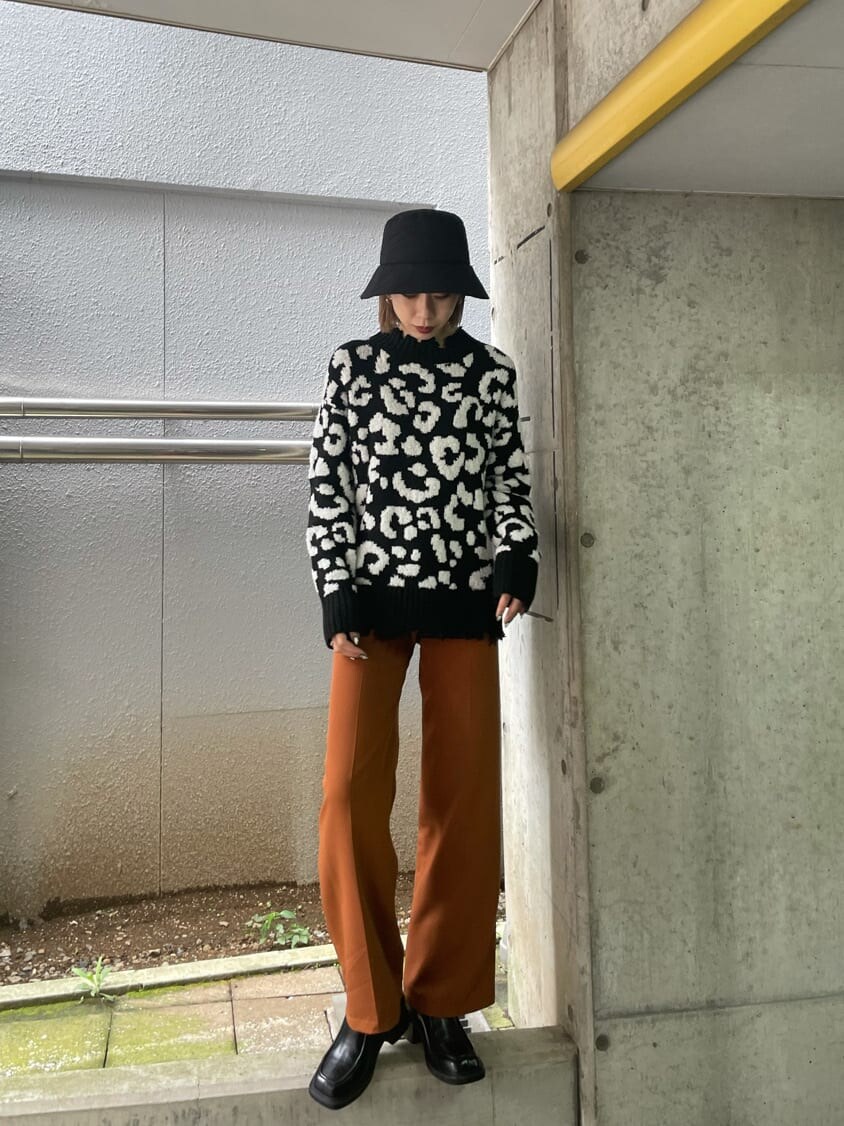 オレンジ系のその他パンツ、ブラック系のブーツ、ブラック系のニット/セーターを着用したレディースの秋コーディネートの3枚目の写真
