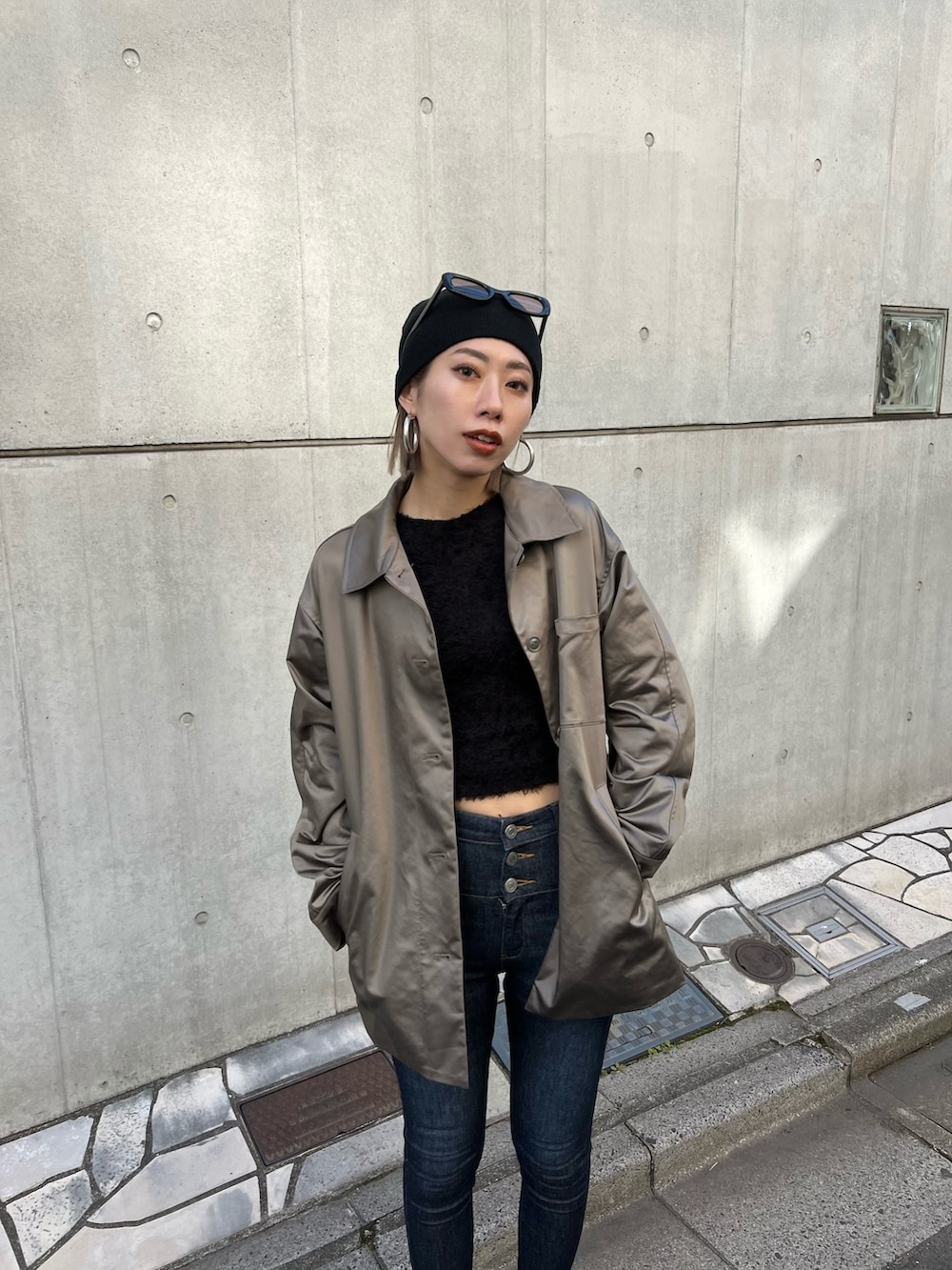 ブルー系のデニムパンツ、ブラック系のブーツ、ブラウン系のナイロンジャケットを着用したレディースの春コーディネートの3枚目の写真