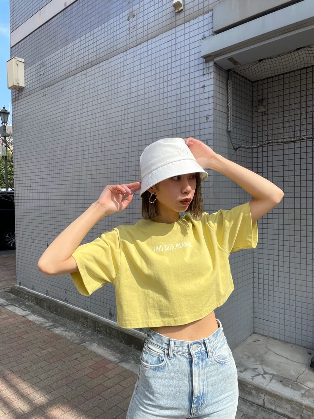 ブルー系のデニムパンツ、イエロー系のTシャツ/カットソー、ホワイト系のサンダルを着用したレディースの春コーディネートの5枚目の写真