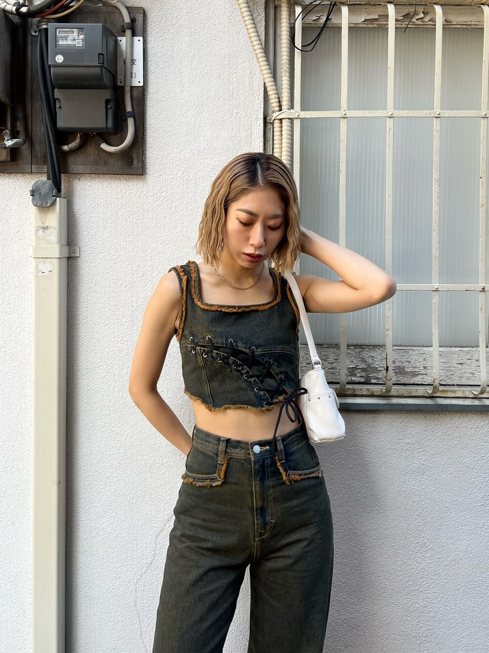 ブルー系のデニムパンツ、ブルー系のタンクトップ、ブラック系のサンダルを着用したレディースの春コーディネートの3枚目の写真