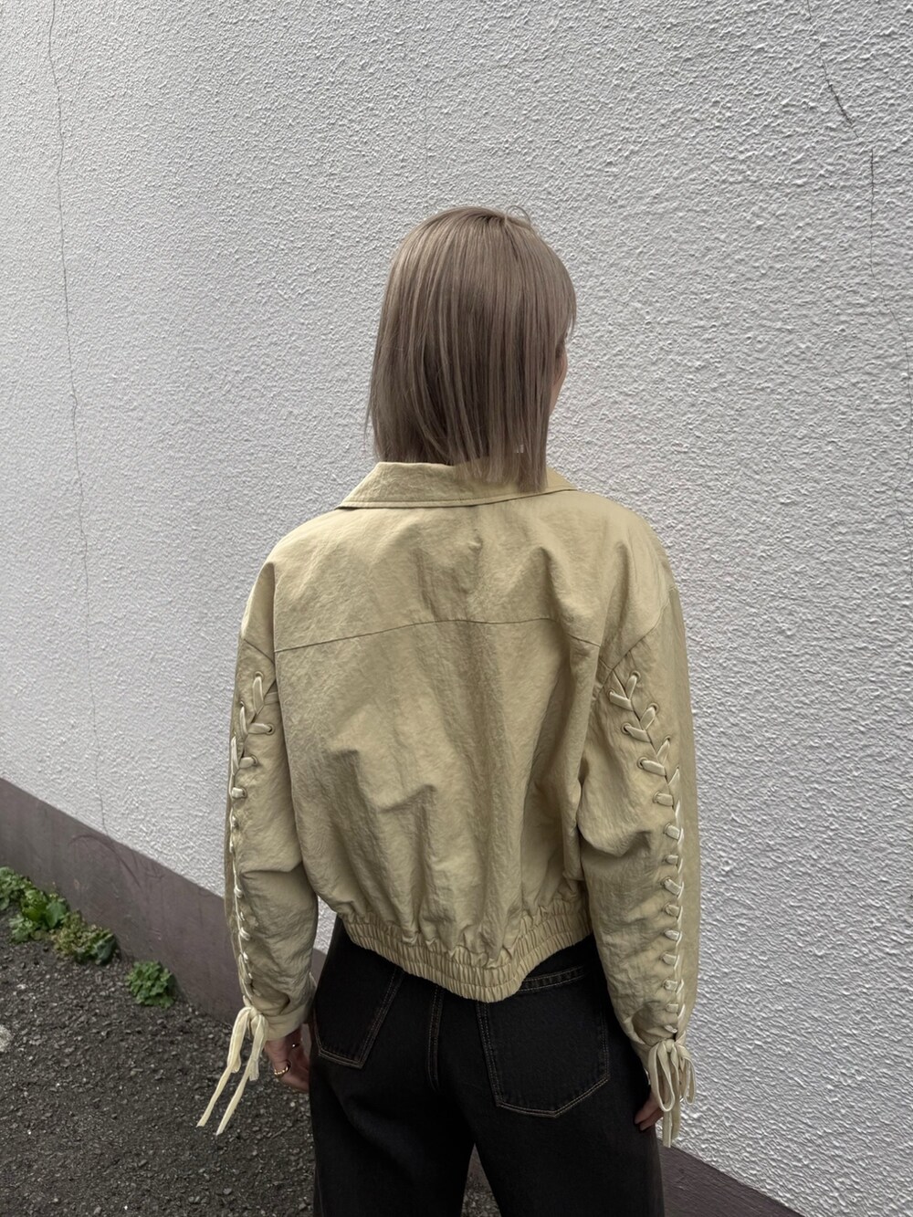 ブルー系のデニムパンツ、ホワイト系のスニーカー、イエロー系のブルゾンを着用したレディースの冬コーディネートの5枚目の写真