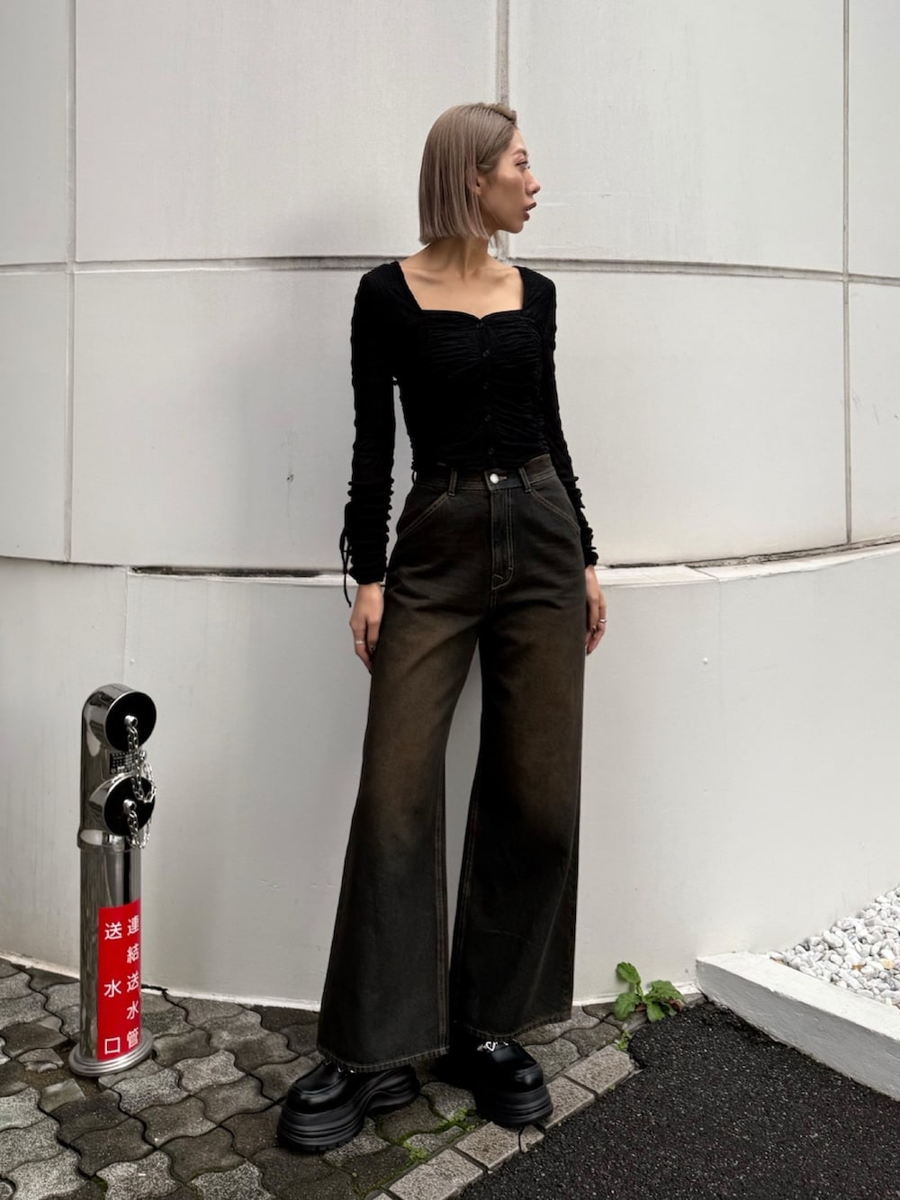 ブルー系のデニムパンツ、ブラック系のTシャツ/カットソー、ブラック系のローファーを着用したレディースの春コーディネートの4枚目の写真