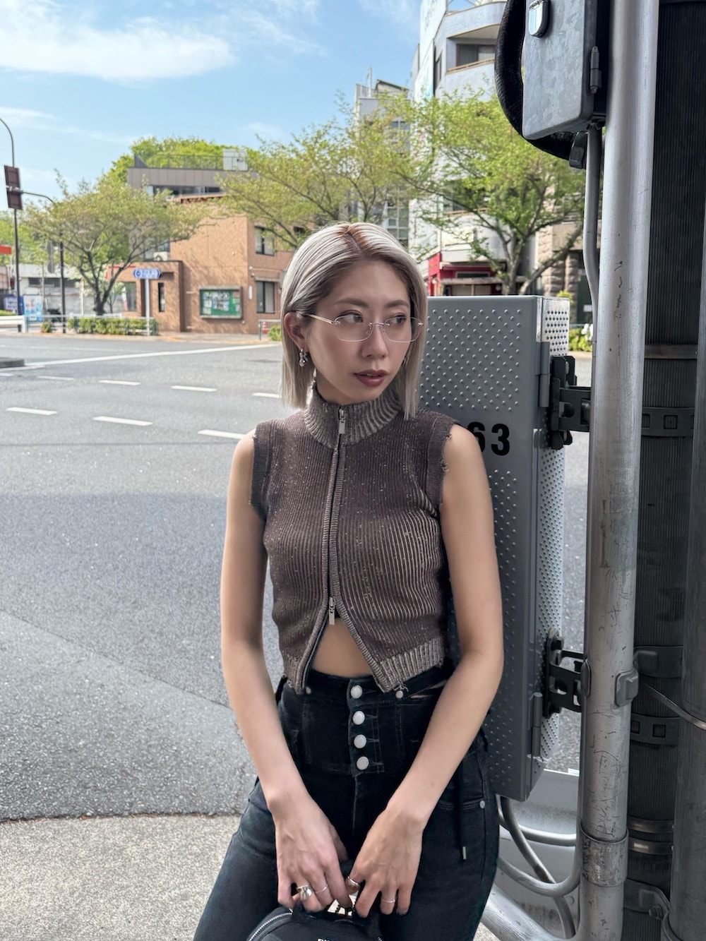ブラック系のデニムパンツ、ブラック系のハンドバッグ、ブラック系のサンダルを着用したレディースの夏コーディネートの4枚目の写真