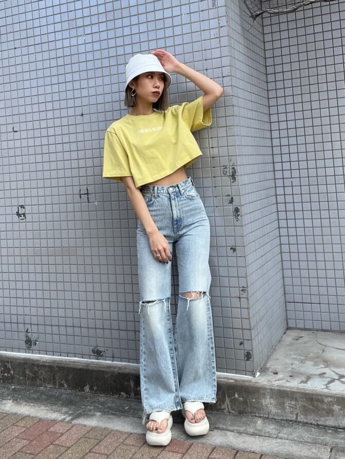 ブルー系のデニムパンツ、イエロー系のTシャツ/カットソー、ホワイト系のサンダルを着用したレディースの春コーディネートの2枚目の写真