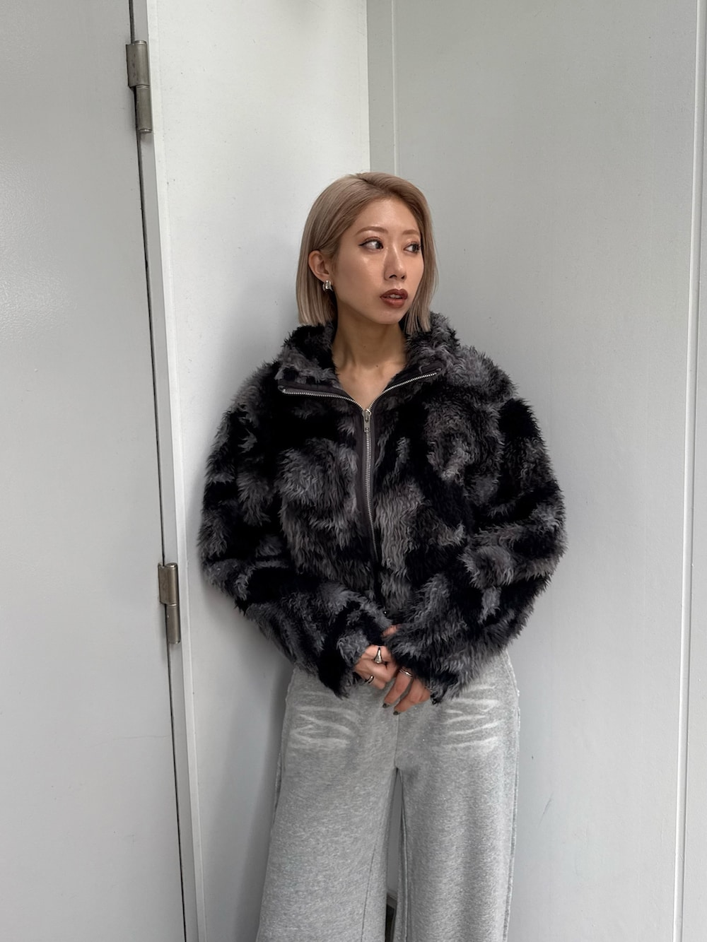 ブルー系のブルゾン、グレー系のスウェットパンツ、ブラック系のブーツを着用したレディースの秋コーディネートの2枚目の写真