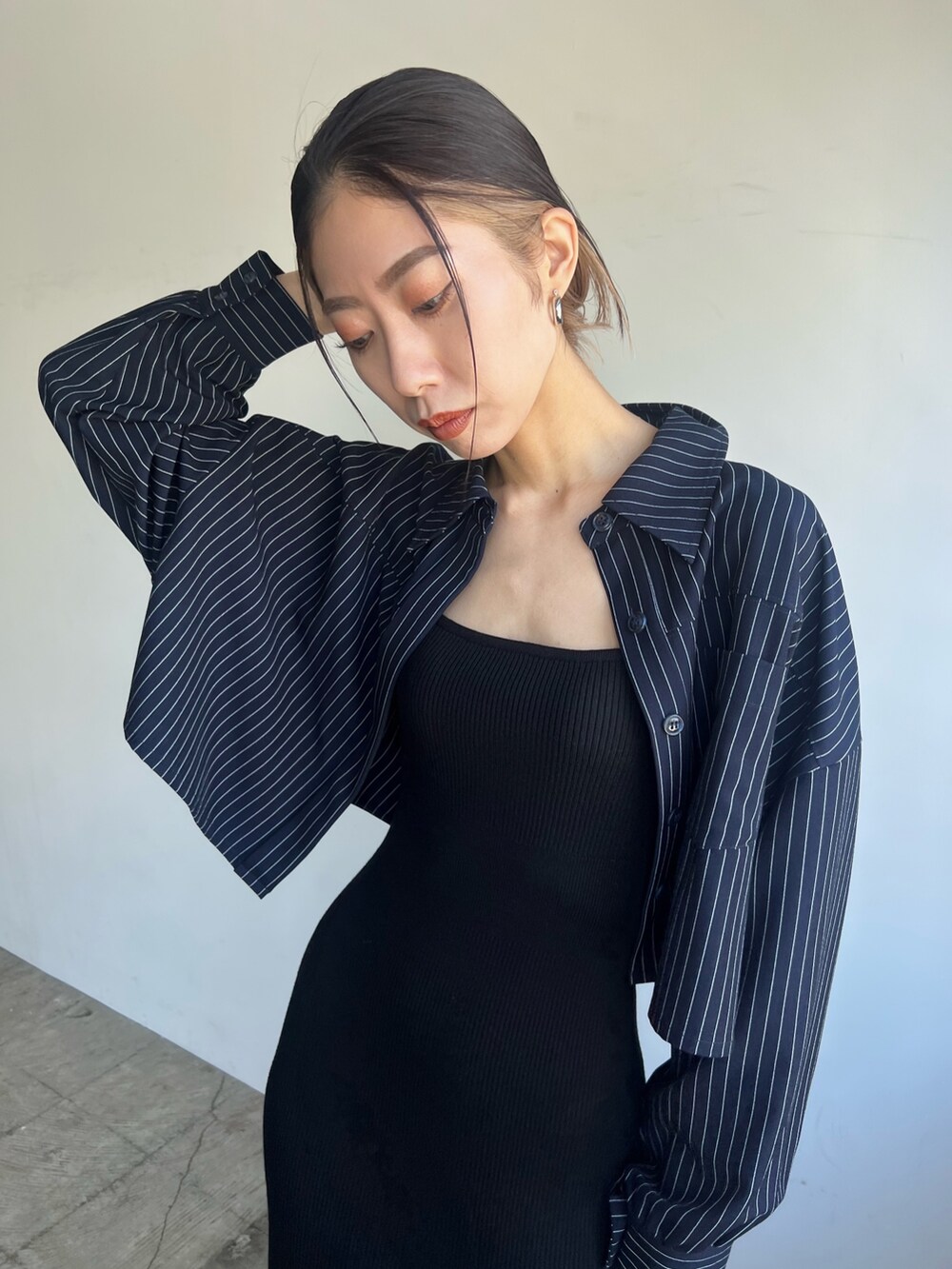 ブラック系のワンピース、ブラック系のブーツを着用したレディースの春コーディネートの3枚目の写真